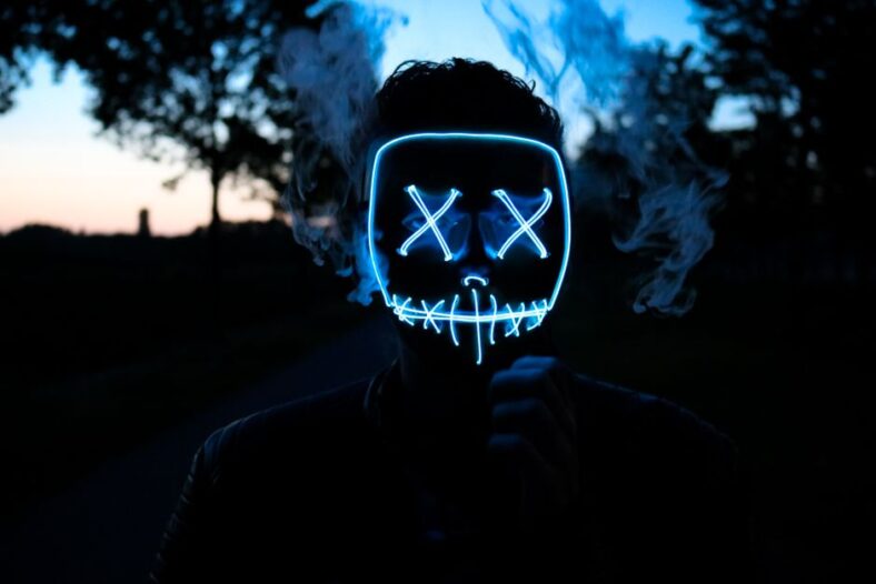 Een vrouw met een LED gezichtsmasker dat rood licht therapie gebruikt voor acnebestrijding en huidverjonging.